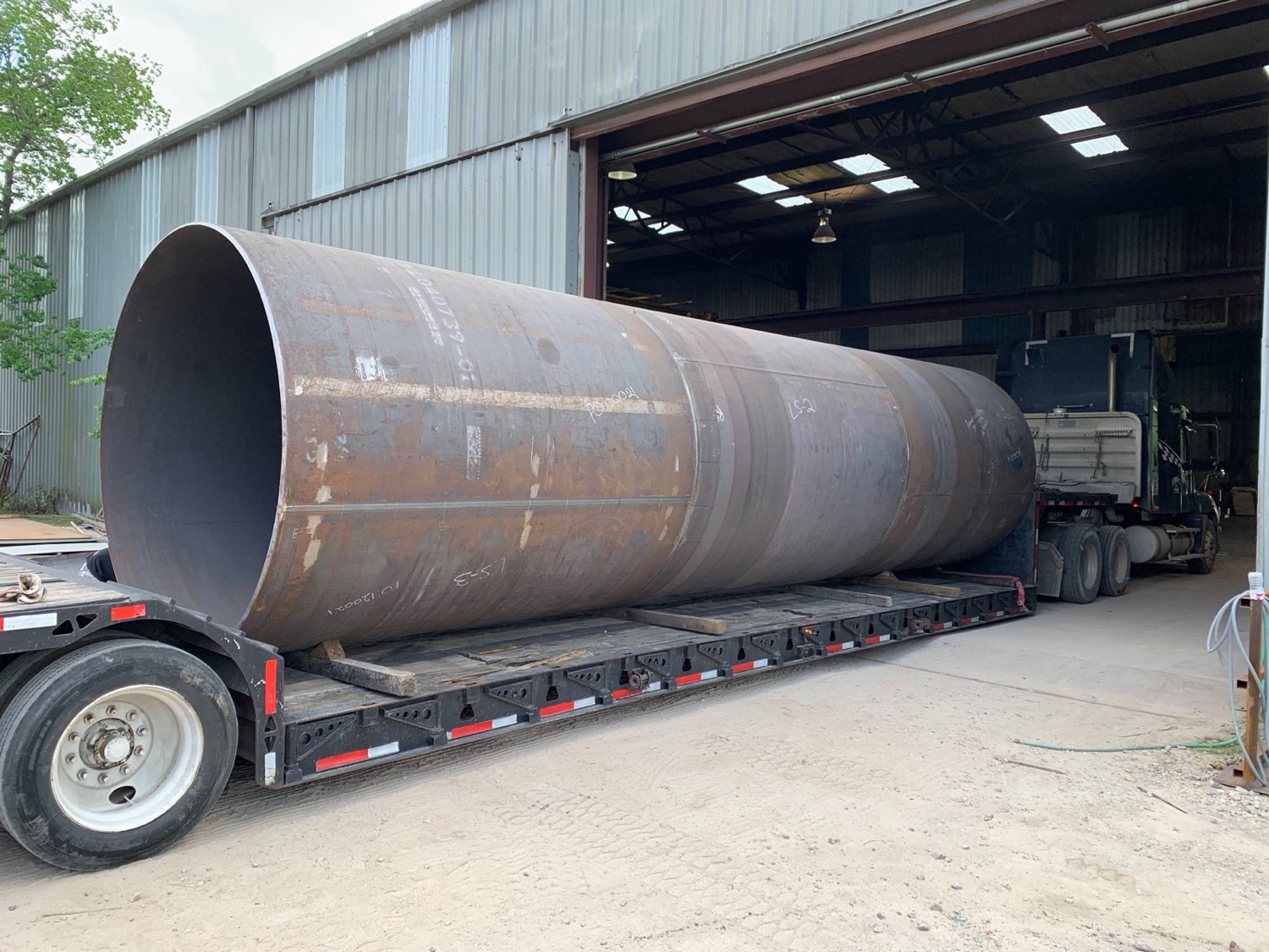 A large rolled shell loaded on a flatbed