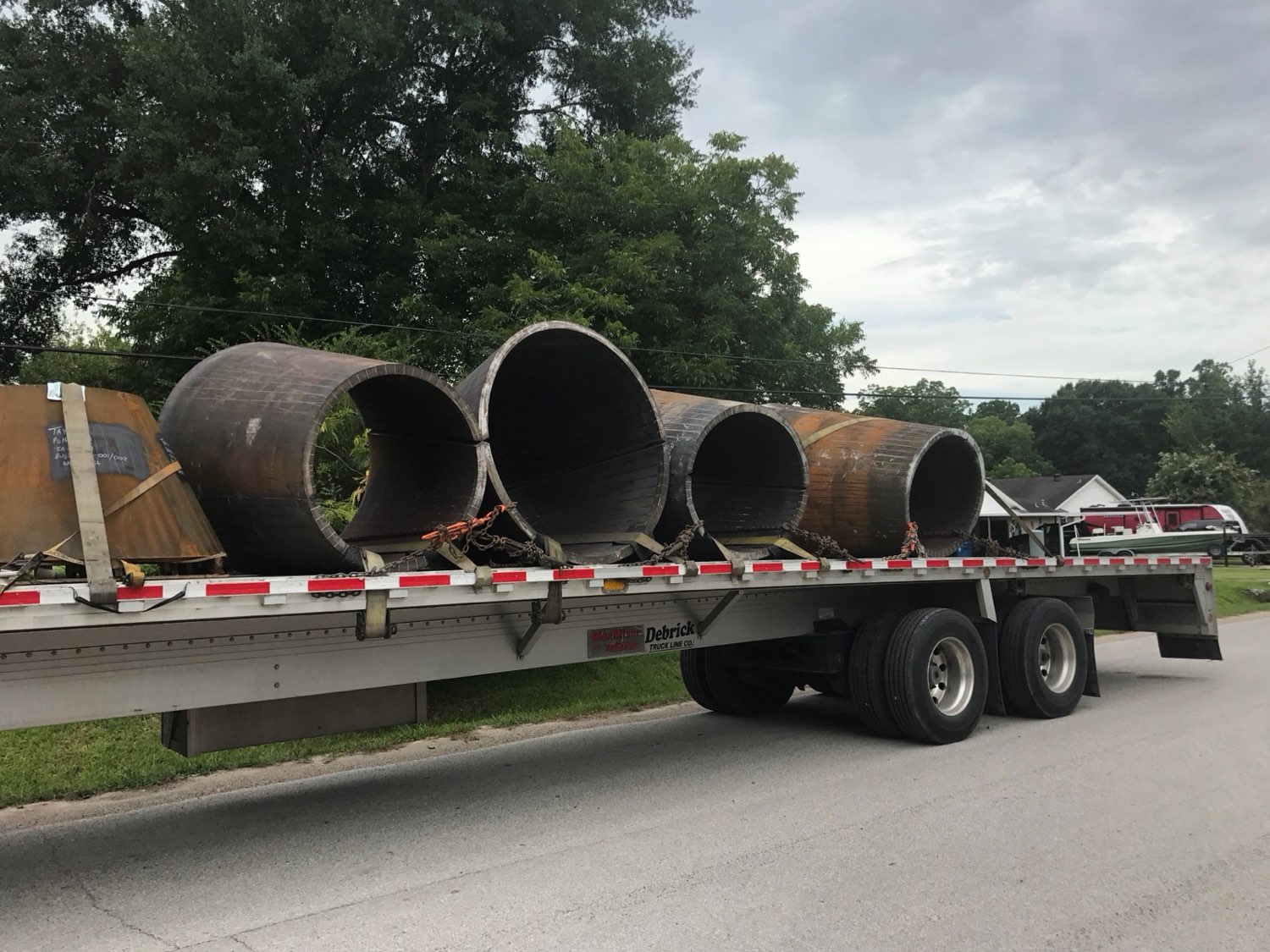 Rolled steel shells strapped to a flatbed for delivery
